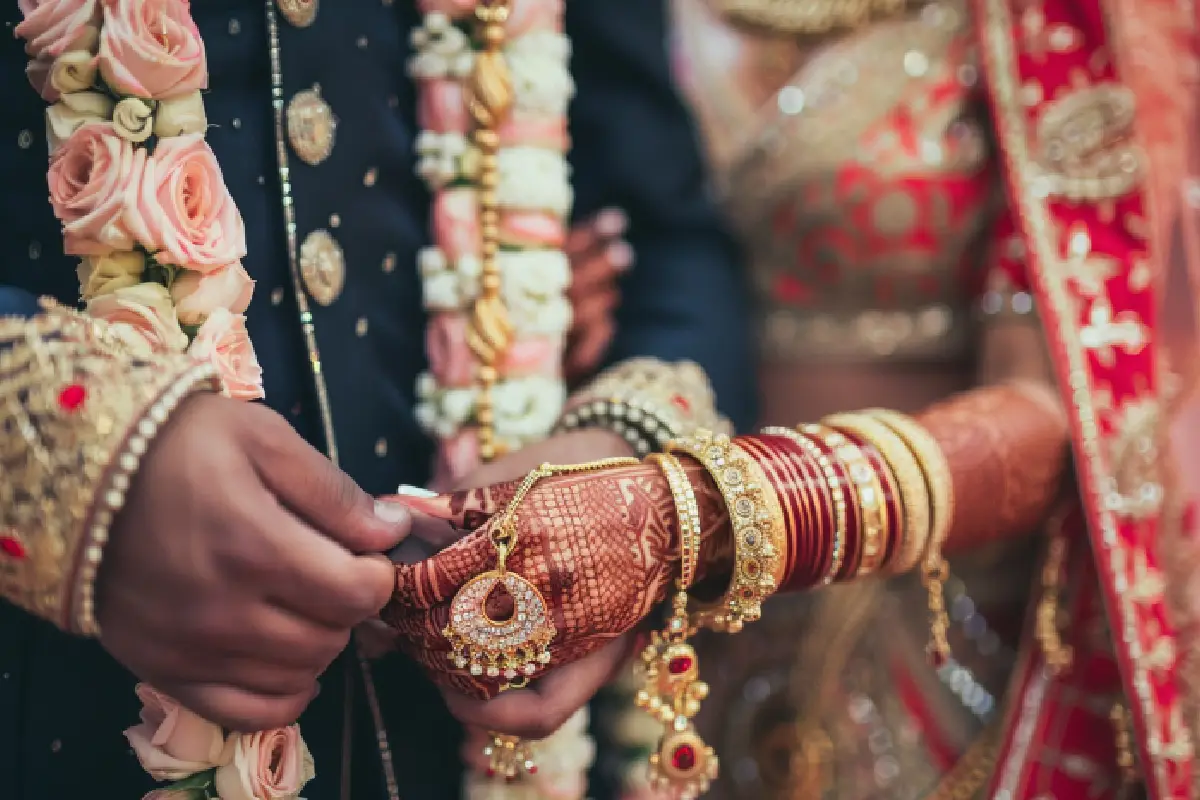 Henna-decorated bride’s hand held during November marriage muhurat.